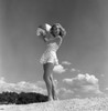 Young woman wearing swimsuit standing on beach and holding beach ball Poster Print - Item # VARSAL255418012