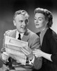 Senior man holding a bill with a senior woman sitting beside him Poster Print - Item # VARSAL25528214