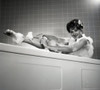 Portrait of young woman washing leg in bath Poster Print - Item # VARSAL255418389D