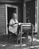 Senior woman churning butter in a butter churn Poster Print - Item # VARSAL25549051