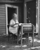 Senior woman churning butter in a butter churn Poster Print - Item # VARSAL25549051