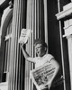 Boy selling newspaper in front of a building Poster Print - Item # VARSAL25536154