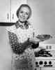 Mature woman holding a plate of food and smiling Poster Print - Item # VARSAL25535519