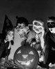 Four children wearing Halloween costumes looking at an illuminated jack o' lantern Poster Print - Item # VARSAL2553525