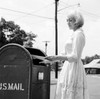 Young woman putting letters in US Mail letter box Poster Print - Item # VARSAL255417681