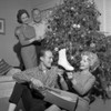 Young woman holding new ice skate  parents standing near Christmas tree Poster Print - Item # VARSAL255417350