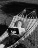 Young woman lying in hammock and reading book Poster Print - Item # VARSAL255422125