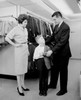 Parents assisting son trying on suit in shop Poster Print - Item # VARSAL255417875