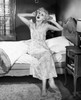Young woman sitting on bed and stretching Poster Print - Item # VARSAL2553744