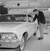 Man examining new car in salesroom Poster Print - Item # VARSAL255422373