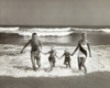 Portrait of parents and their two children running on the beach Poster Print - Item # VARSAL2556762
