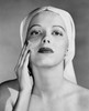 Portrait of young woman applying cream to her face Poster Print - Item # VARSAL2553745