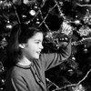 Girl holding Christmas decoration above Christmas tree Poster Print - Item # VARSAL255416405