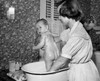 Young woman washing her baby in a washtub Poster Print - Item # VARSAL2559883