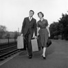 Young couple with suitcase walking at train station Poster Print - Item # VARSAL255416236