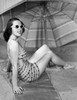 Young woman sitting under beach umbrella Poster Print - Item # VARSAL2557227