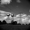 Power lines and water tanks against cloudy sky Poster Print - Item # VARSAL255424690