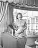 Young woman holding cushions and smiling Poster Print - Item # VARSAL25520758