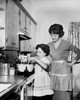 Side profile of a girl preparing food in the kitchen with her mother standing beside her Poster Print - Item # VARSAL25536220