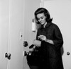 Young woman putting money into purse before leaving house Poster Print - Item # VARSAL255417757