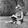 Student sitting on grass and reading book Poster Print - Item # VARSAL255417418