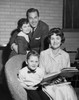 Mid adult couple with their children in a living room Poster Print - Item # VARSAL2553806