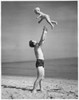 Side profile of a father tossing his son into the air at the beach Poster Print - Item # VARSAL25519682