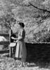 Woman taking letter from mailbox Poster Print