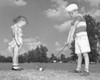 Boy playing golf with his sister standing in front of him Poster Print - Item # VARSAL25516291