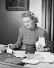 Mid adult woman sitting at a desk and sorting bills Poster Print - Item # VARSAL25548461