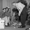 Family near Christmas tree watching man playing mini golf Poster Print - Item # VARSAL255417351