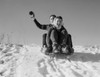 Young couple sledding down snowy hill Poster Print - Item # VARSAL255422699