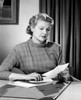 Woman sitting at desk reading letter Poster Print - Item # VARSAL25549188