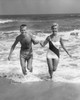 Portrait of a young couple running on the beach Poster Print - Item # VARSAL25516450
