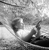 Woman reading newspaper in hammock Poster Print - Item # VARSAL255416456