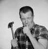 Studio shot of mature man holding hammer and licking finger Poster Print - Item # VARSAL255422691