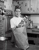 Young woman standing in a kitchen holding a jar Poster Print - Item # VARSAL25541750