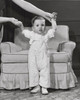 Baby girl standing in front of an armchair Poster Print - Item # VARSAL2557569