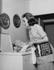 Side profile of a young woman putting clothes into a washing machine Poster Print - Item # VARSAL25541852