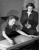 Businesswoman undergoing a manual dexterity test with another businesswoman standing beside her Poster Print - Item # VARSAL25536965