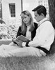 Young couple sitting on grass and reading book Poster Print - Item # VARSAL25518263