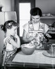 Mid adult woman and her daughter preparing food in a kitchen Poster Print - Item # VARSAL25542778