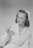 Young nurse looking at thermometer Poster Print - Item # VARSAL255422900