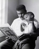 Close-up of a son sitting on his father's lap reading a book Poster Print - Item # VARSAL2553401