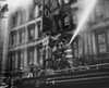 Low angle view of three firemen spraying water on a burning movie theater  New York City  New York State  USA Poster Print - Item # VARSAL255547