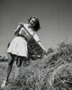 Portrait of a young woman standing near a heap of straw Poster Print - Item # VARSAL25531462