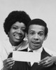 Portrait of a young woman smiling with a young man and holding a check Poster Print - Item # VARSAL2555324