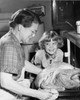 Side profile of senior woman putting roasted turkey in oven with her granddaughter smiling Poster Print - Item # VARSAL2554933