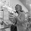 Enthusiastic young woman at cosmetics stand in supermarket Poster Print - Item # VARSAL255421093