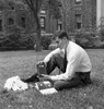 Portrait of male student reading book and listening to radio outside university building Poster Print - Item # VARSAL255420785